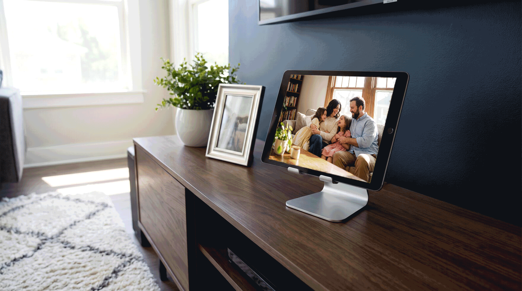 An iPad on a stand in a living room, playing a slideshow of photos